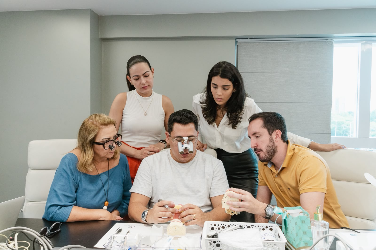 Alunos analisando modelo de laminados cerâmicos durante aula prática em turma
