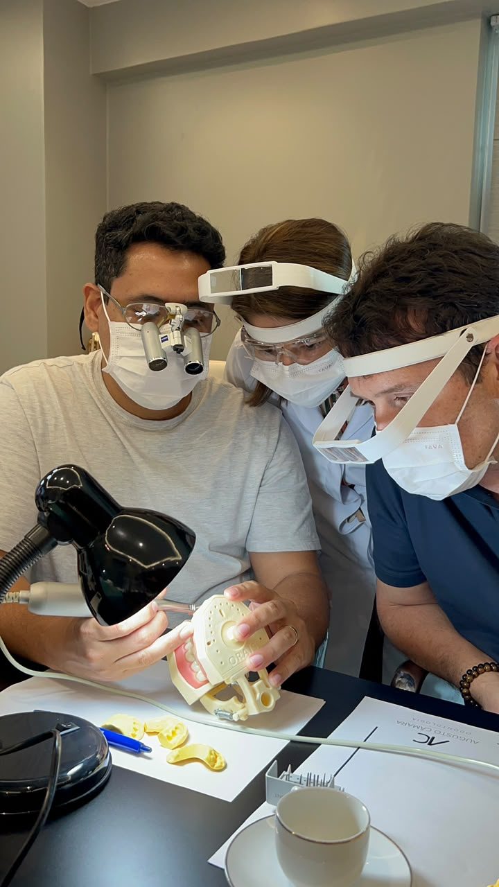 Alunos analisando preparo de laminados cerâmicos em modelo odontológico