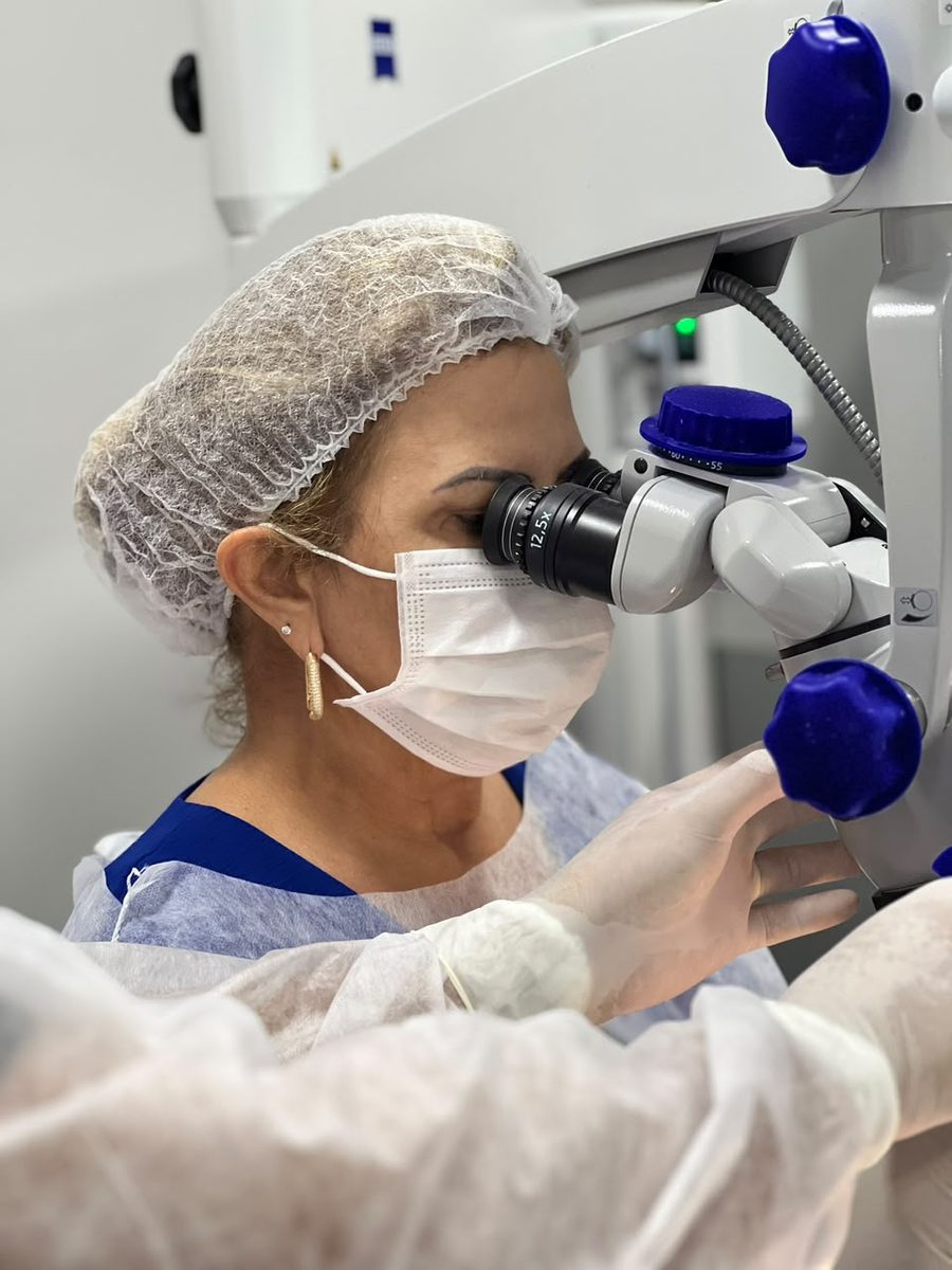 Dentista utilizando microscópio Carl Zeiss durante prática de laminados cerâmicos