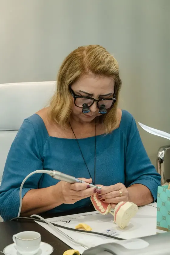 Aluna praticando preparo de laminados cerâmicos em modelo odontológico