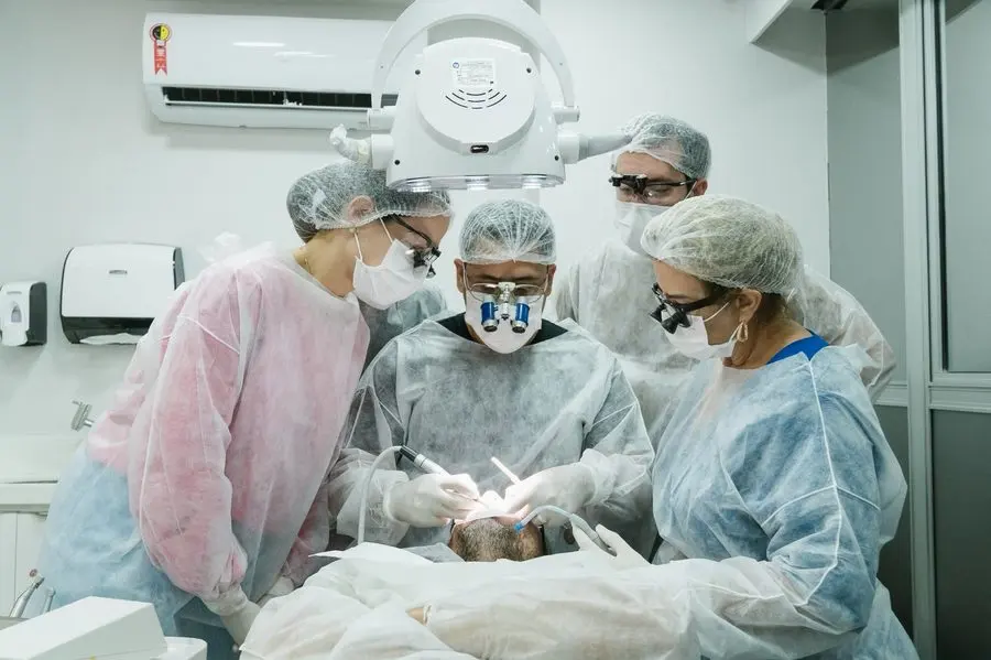 Turma acompanhando caso clínico ao vivo de laminados cerâmicos no consultório